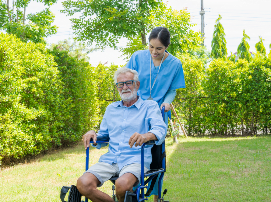 Elder on a wheelchair being push by a cna.