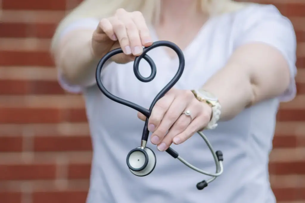 A women a holding a doctor stesthoscope.